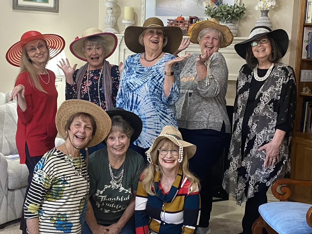 8 women in a group photo with wide brim hats